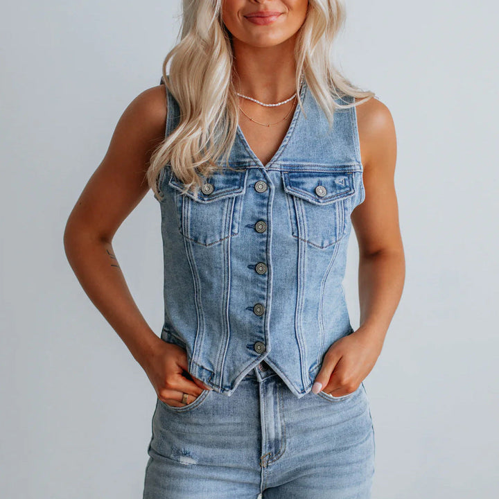 Women's denim vest with button placket and modern cut details. 1
